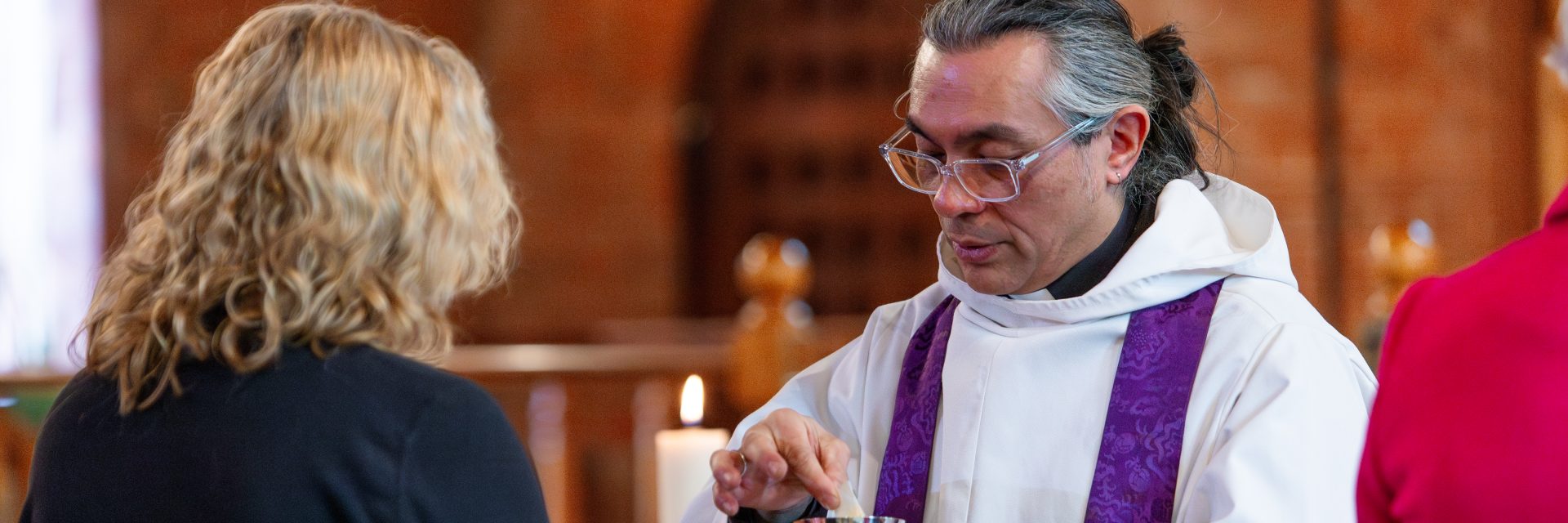 Revd Tim Yau giving bread to a parishioner at Holy Communion.