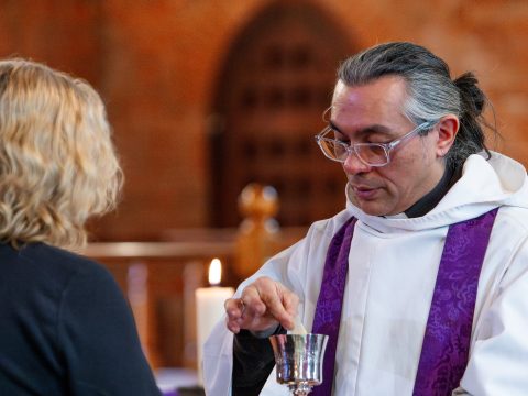 Revd Tim Yau giving bread to a parishioner at Holy Communion.