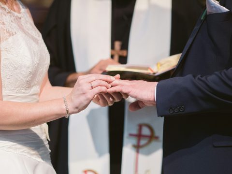 a man and woman exchanging rings at their wedding in a church